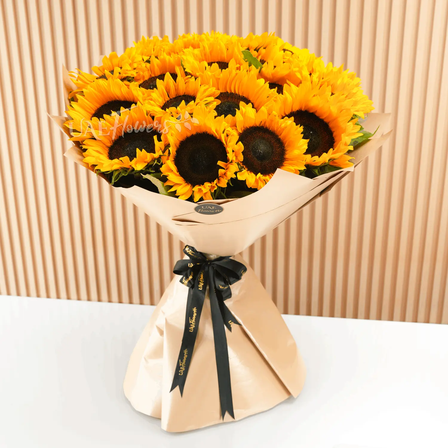 Bouquet of 20 sunflowers with fillers in brown wrapping paper and tied with ribbons.