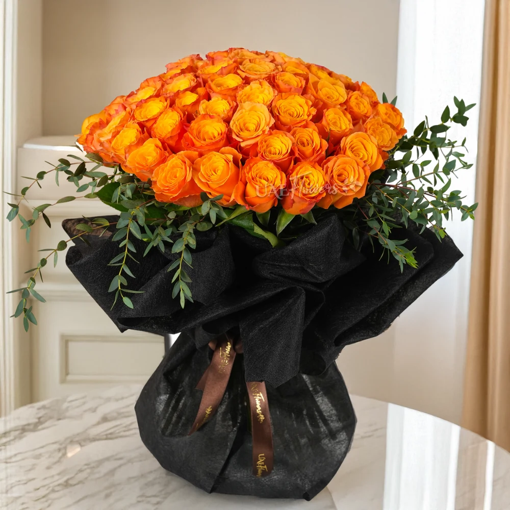 Bouquet of 40 orange roses in black wrapping paper with green fillers