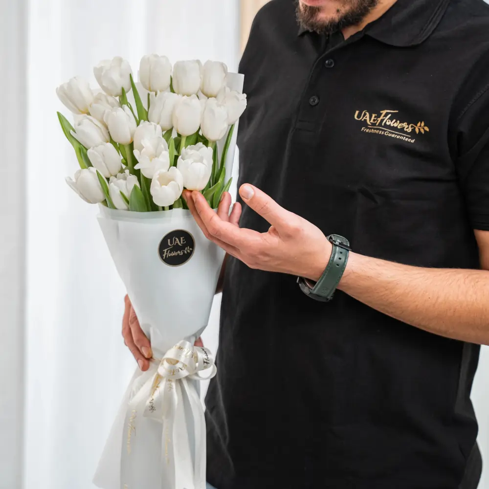 Bouquet of 20 white tulips in premium white wrapping tied with satin ribbon.