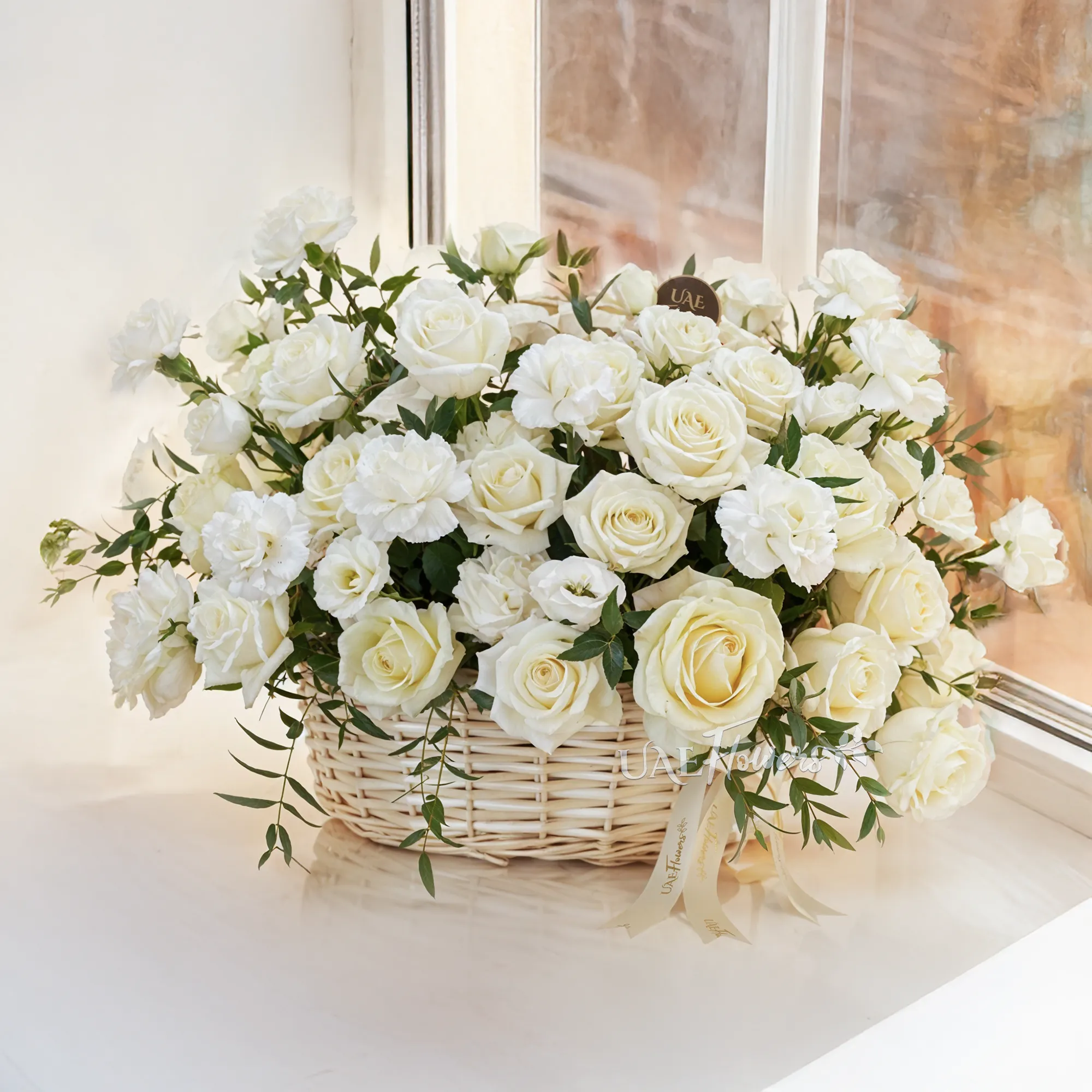 A basket arrangement of 15 white carnations and 15 white roses and fillers.